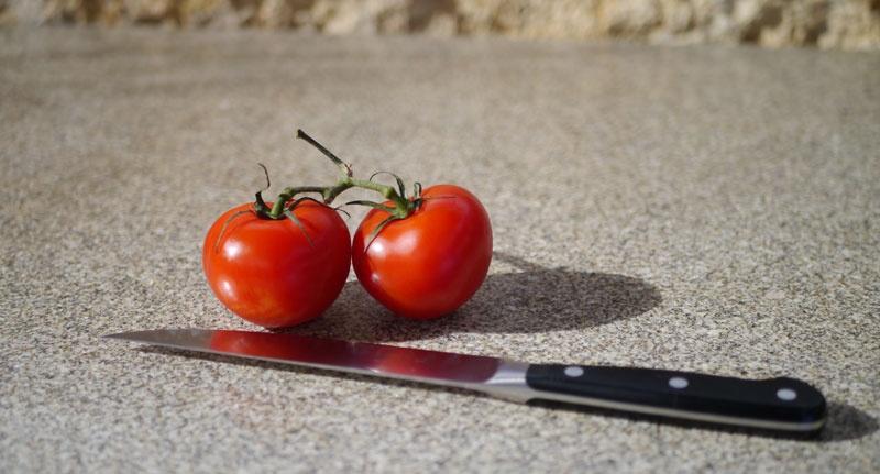 Granitarbeitsplatte mit Tomaten und Messer
